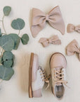 leather bows and saddle shoes featured in sand