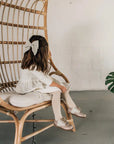 model wearing leather bows and shoes featured in sand/fog