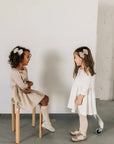 models wearing leather bows and shoes featured in sand/fog