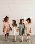 models wearing leather shoes and bows featured in colors fog, sand, peony, and terrazzo