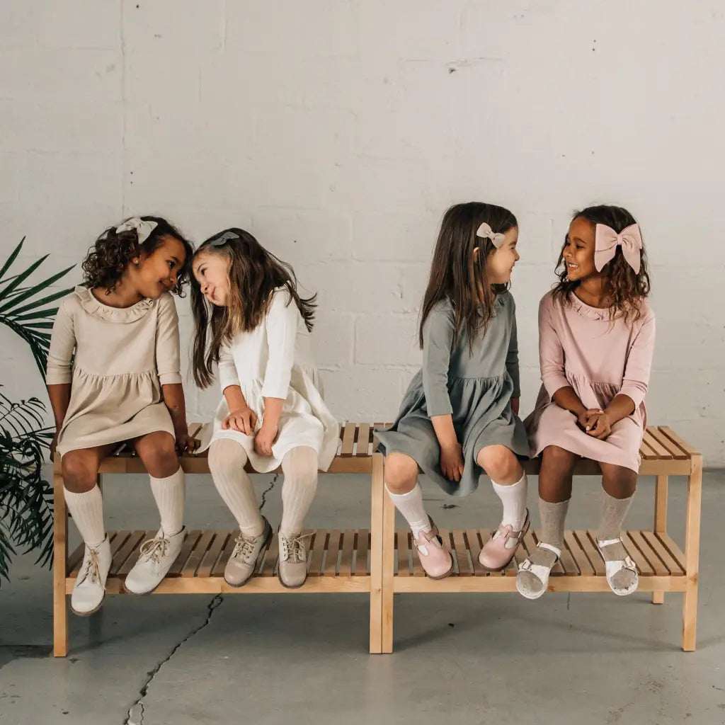 models wearing leather shoes and bows featured in colors fog, sand, peony, and terrazzo