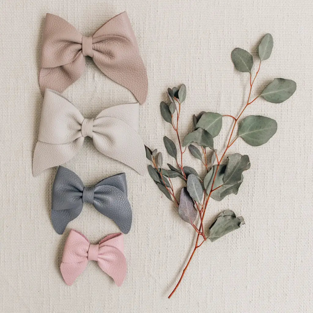 leather bows featured in colors sand, fog, heron, and peony