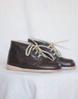 Pair of brown leather shoes with beige laces on a light background