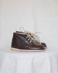 Pair of brown leather shoes with beige laces on a light background