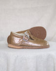 Gold shoe with a buckle on a white background