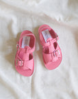 Pair of pink sandals on a white fabric background