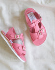 Pair of pink sandals on a white fabric background