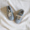 Pair of light blue shoes with beige laces on a white fabric background