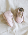 Pair of pink shoes on a white fabric background