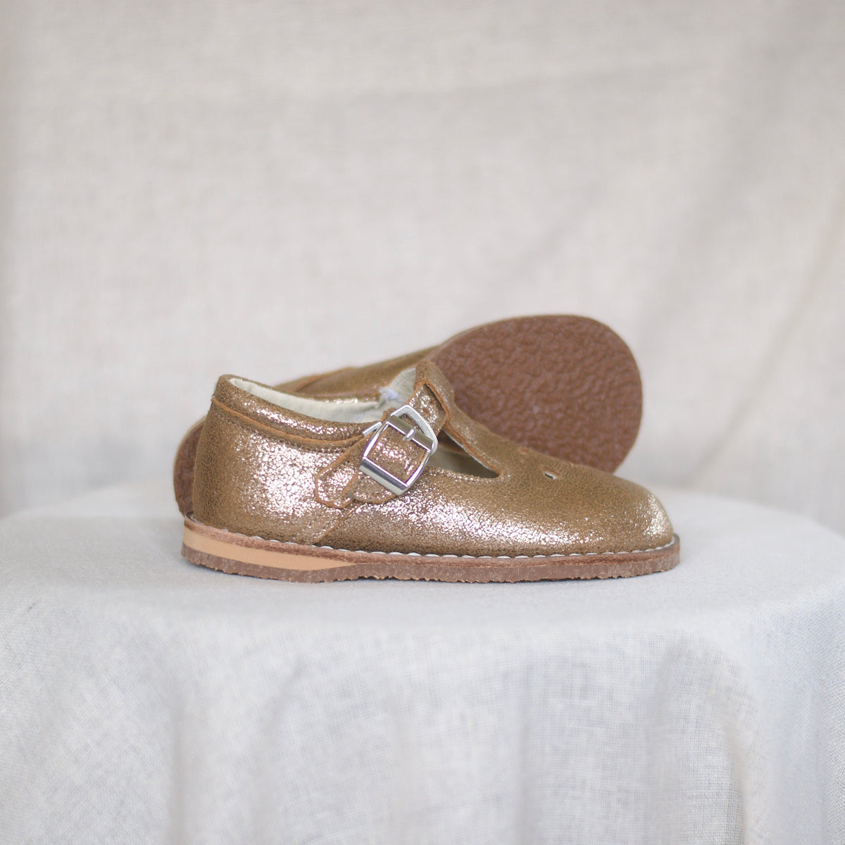 Gold shoe with a buckle on a white background