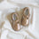 Pair of gold shoes on a white fabric background